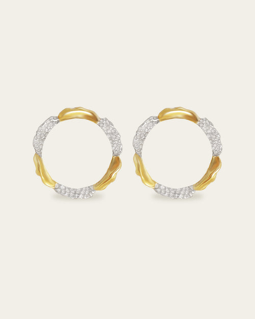 Amusement hoop earrings featuring an alternating pattern of smooth gold and hammered silver-tone segments.