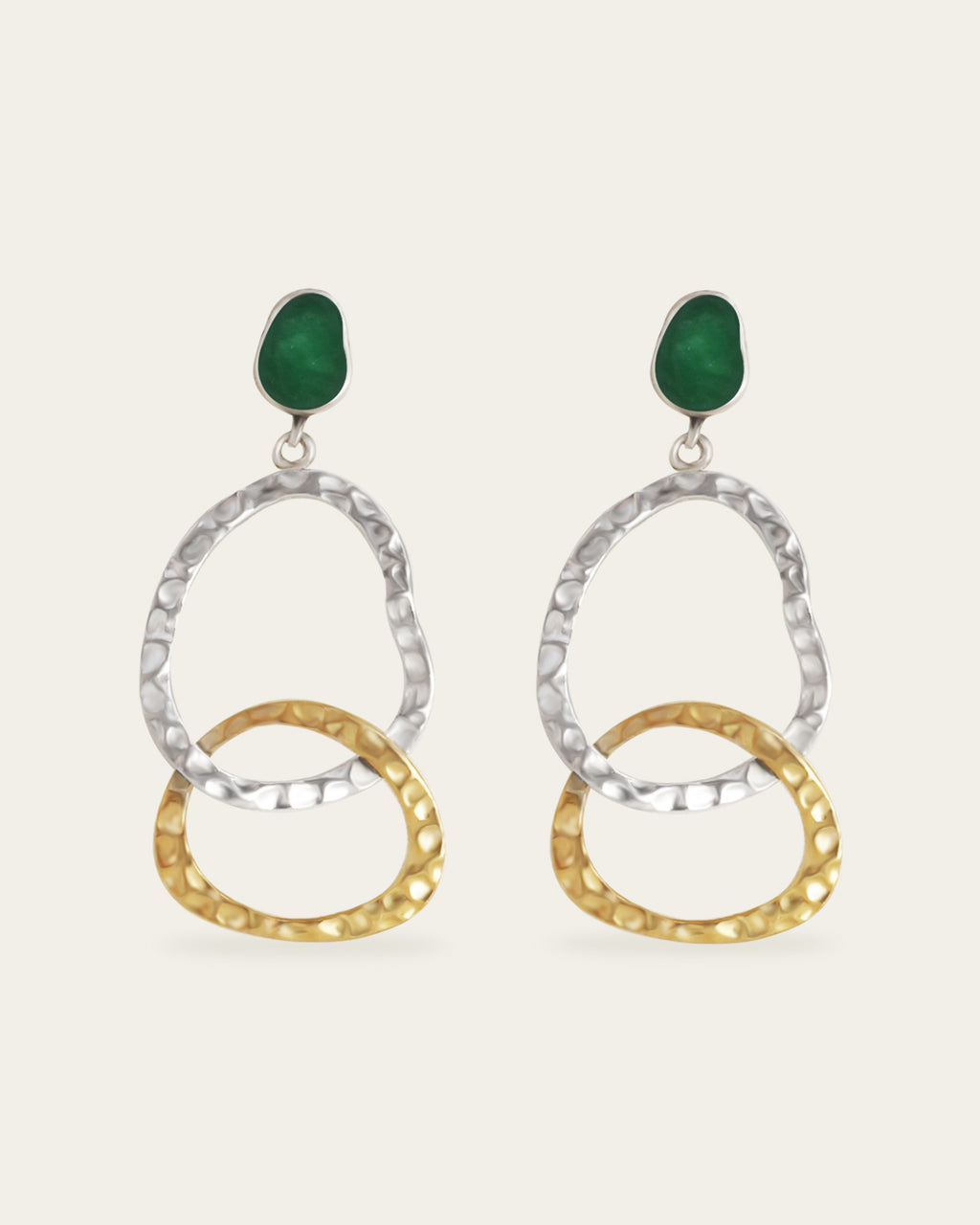 Pair of earrings with gold and silver circular designs and green enamel on a white background