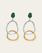 Pair of earrings with gold and silver circular designs and green enamel on a white background