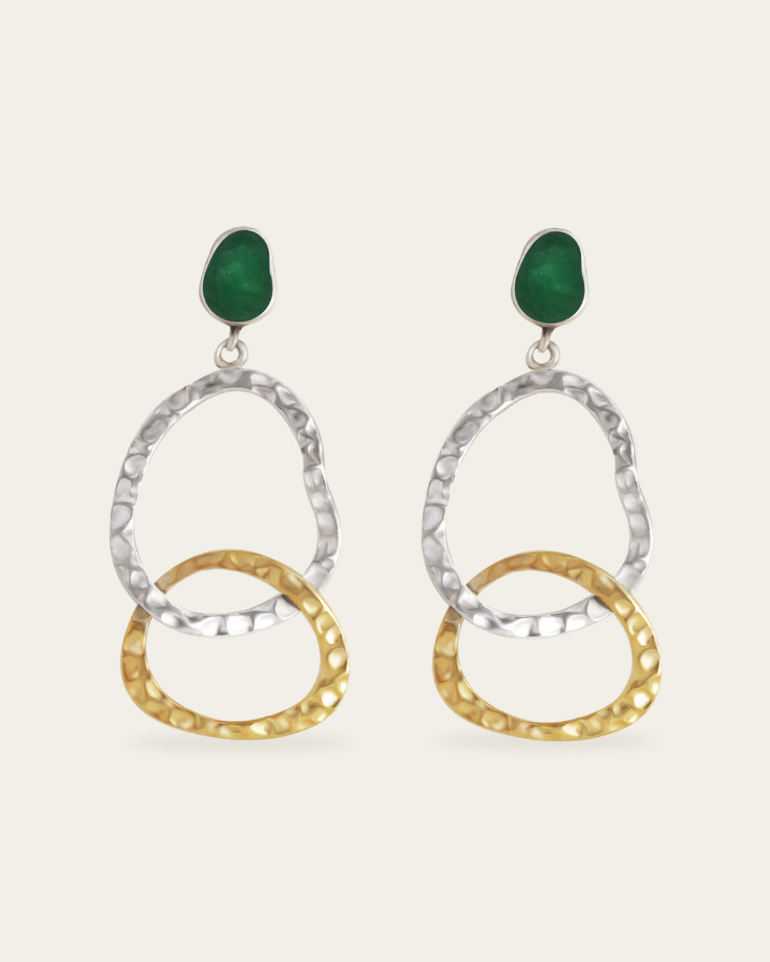 Pair of earrings with gold and silver circular designs and green enamel on a white background
