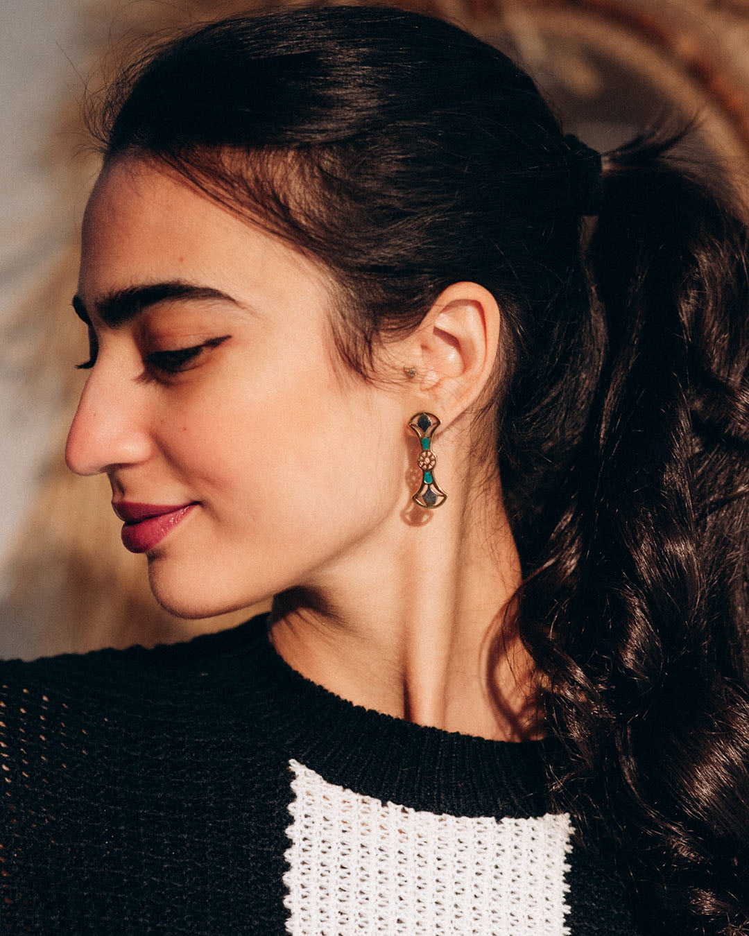 Close-up of a woman wearing Double Lotus STERLING SILVER, 18K Gold plated lotus earrings featuring two tiered lotus flower petals with intricate filigree details.