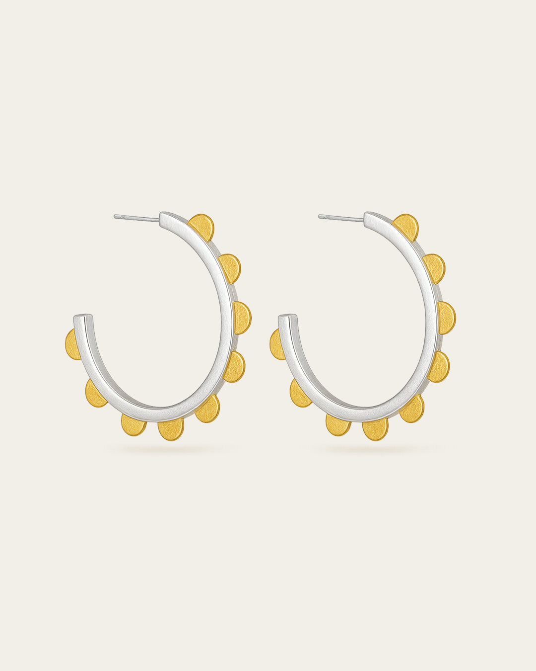Modern Jubilance hoop earrings in matte silver adorned with gold-tone semi-circle charms along the outer edge