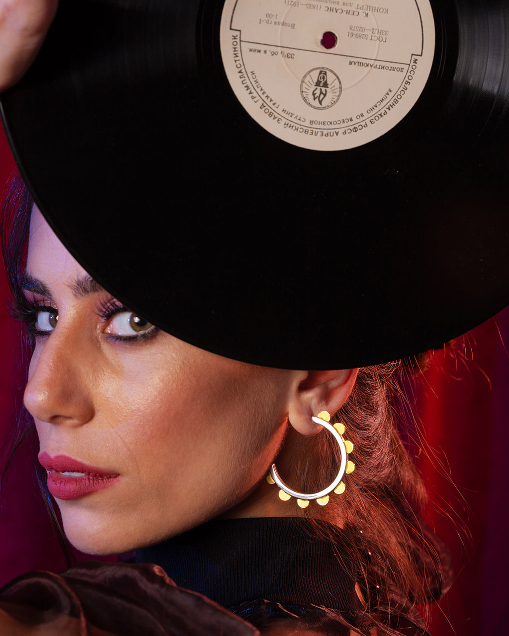 Modern Jubilance hoop earrings in matte silver adorned with gold-tone semi-circle charms along the outer edge