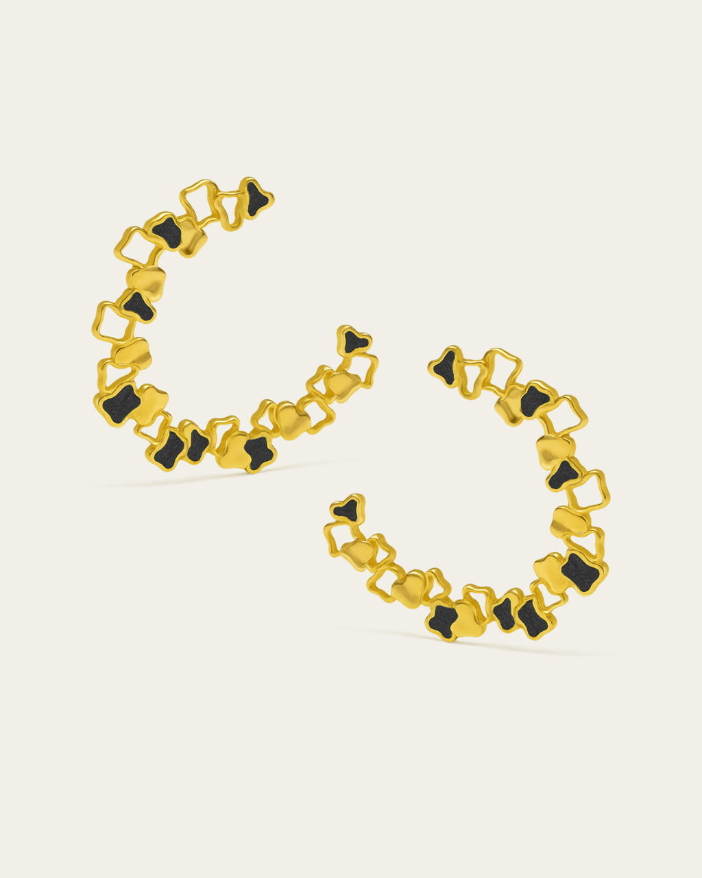 Statement gold Ripple hoop earrings with a textured, open-work design and black enamel accents.