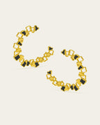 Statement gold Ripple hoop earrings with a textured, open-work design and black enamel accents.