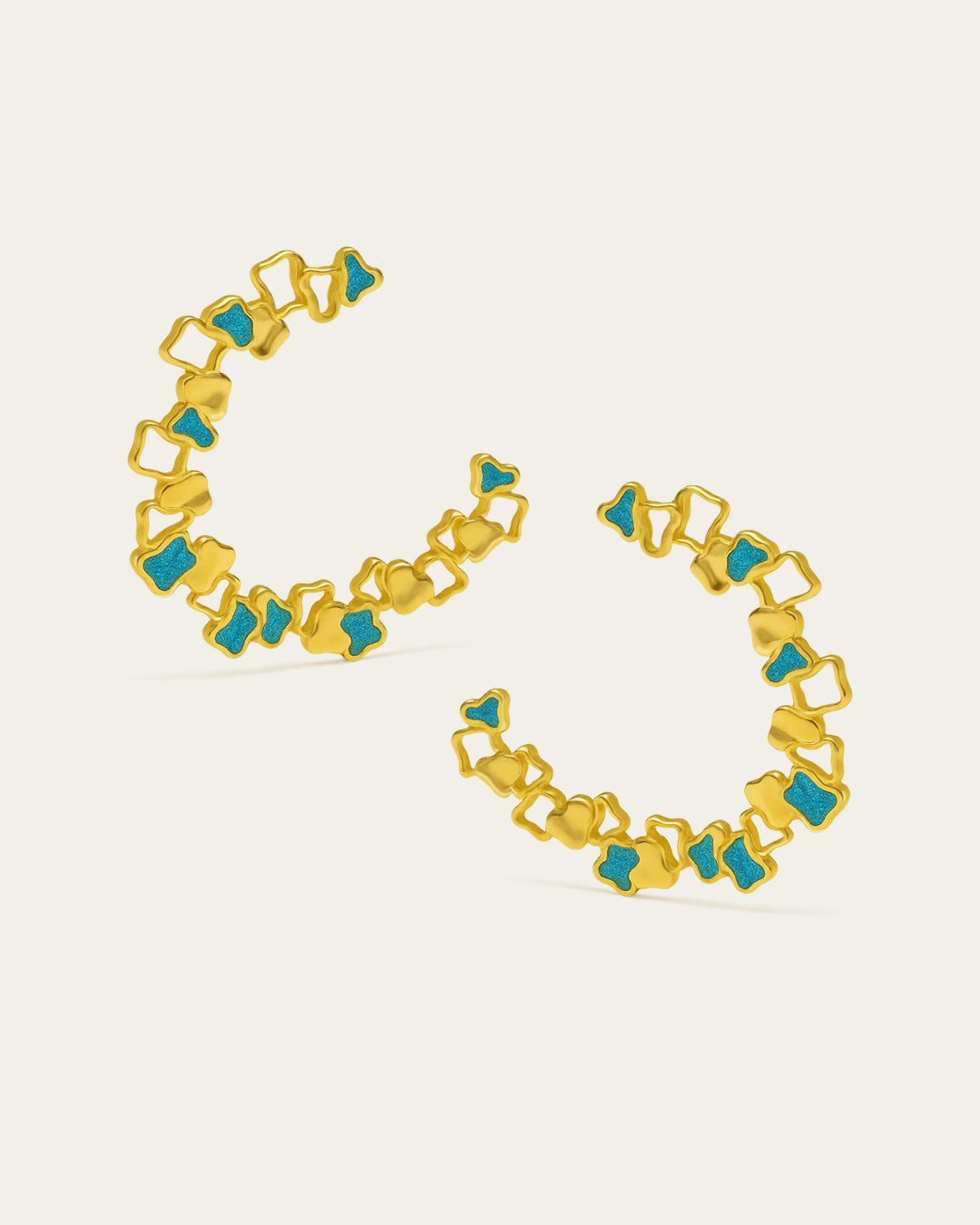 Statement gold Ripple hoop earrings with a textured, open-work design and blue enamel accents.