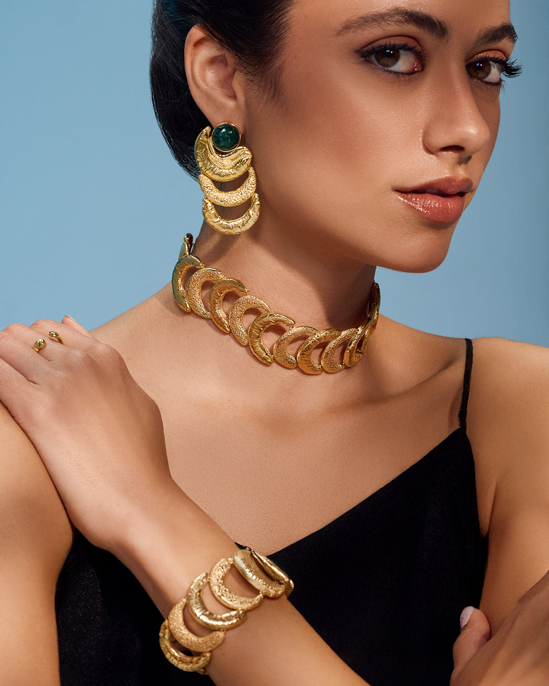 Textured gold Suhail earrings and cuff set with vibrant green gemstone accents in a handcrafted organic design.