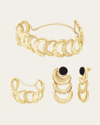 Gold Suhail set featuring black onyx-style stones, a celestial crescent choker, and matching textured jewelry.