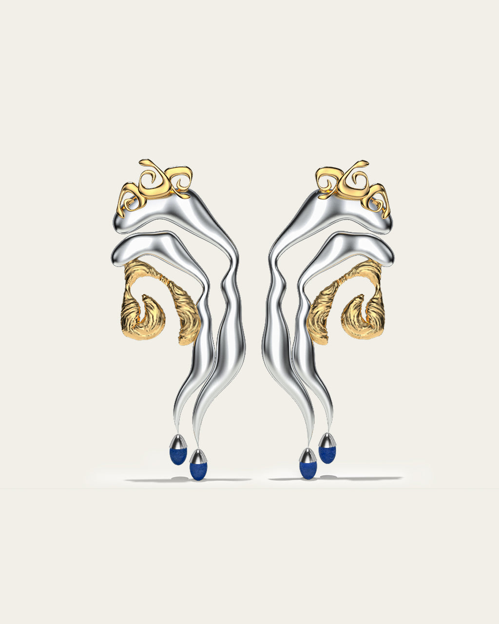 Mixed metal Tide statement earrings in gold and silver with an organic wave design and blue stone drops.