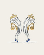 Mixed metal Tide statement earrings in gold and silver with an organic wave design and blue stone drops.