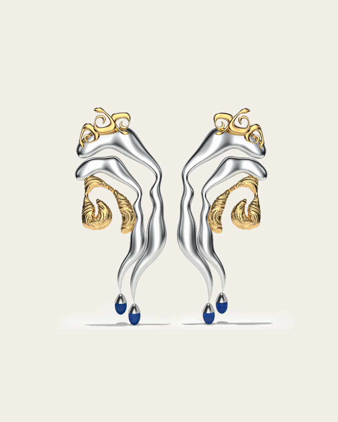 Mixed metal Tide statement earrings in gold and silver with an organic wave design and blue stone drops.