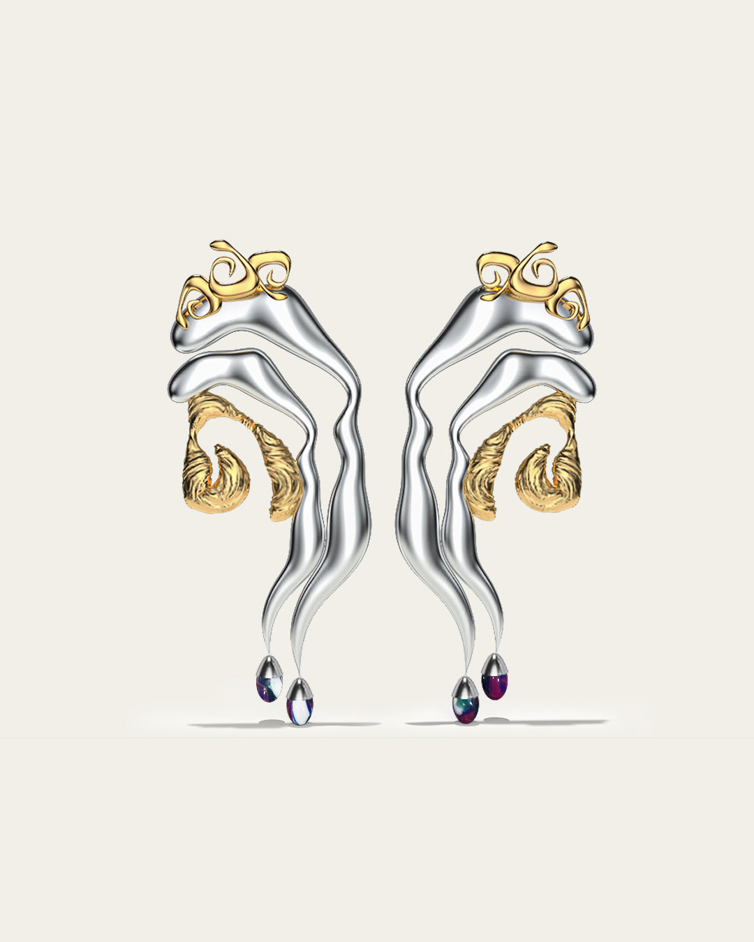 Mixed metal Tide statement earrings in gold and silver with an organic wave design and gradient blue stone drops.