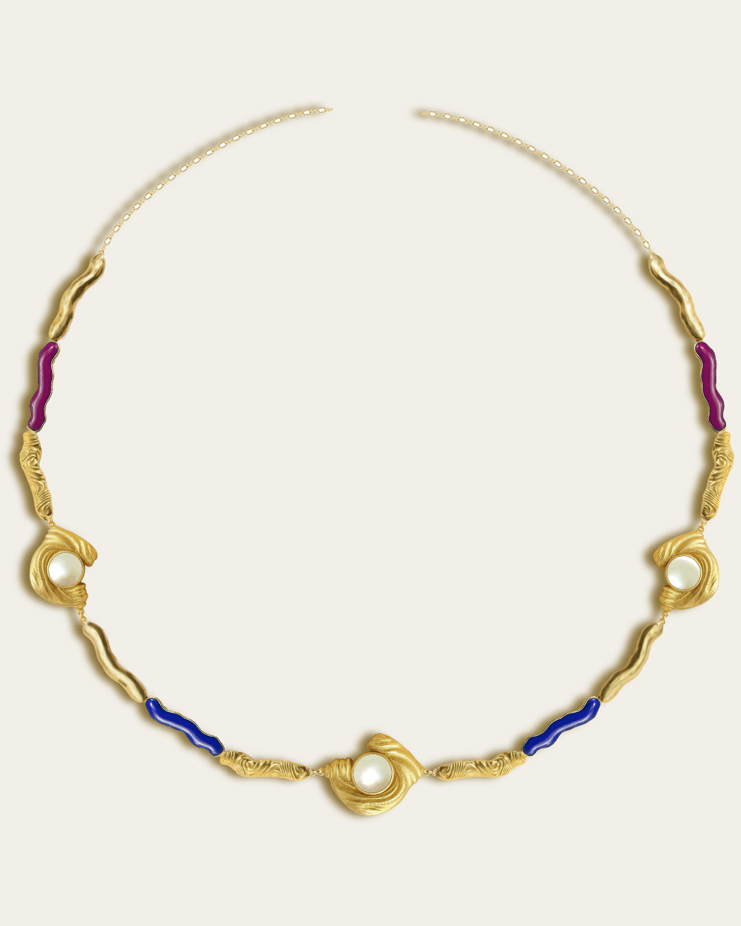 Glema necklace featuring earth-toned blue, magenta resin and a central textured gold charm with a seahell stone