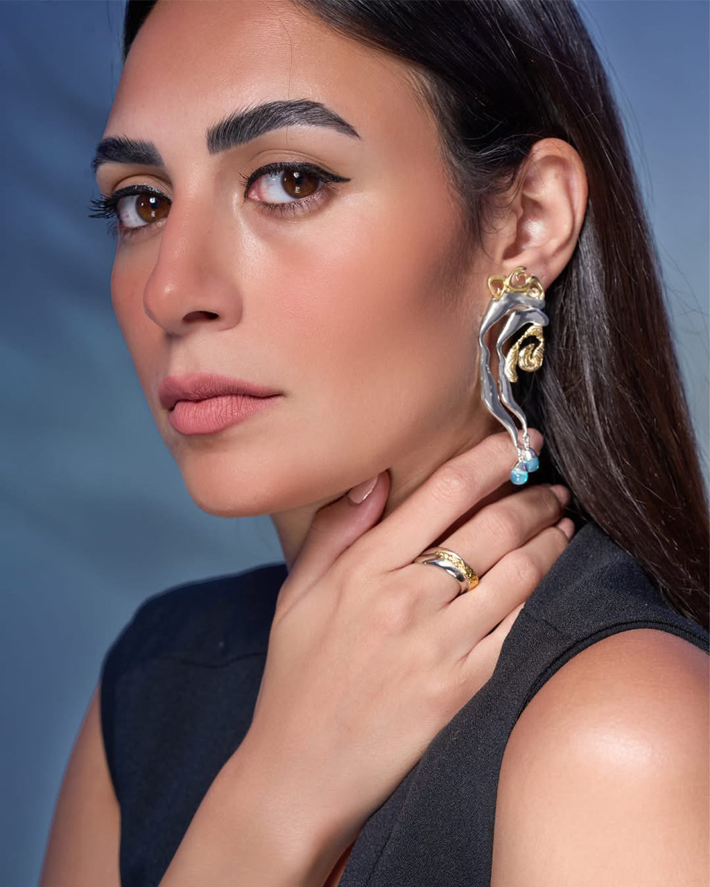 Mixed metal Tide statement earrings in gold and silver with an organic wave design and baby blue stone drops.